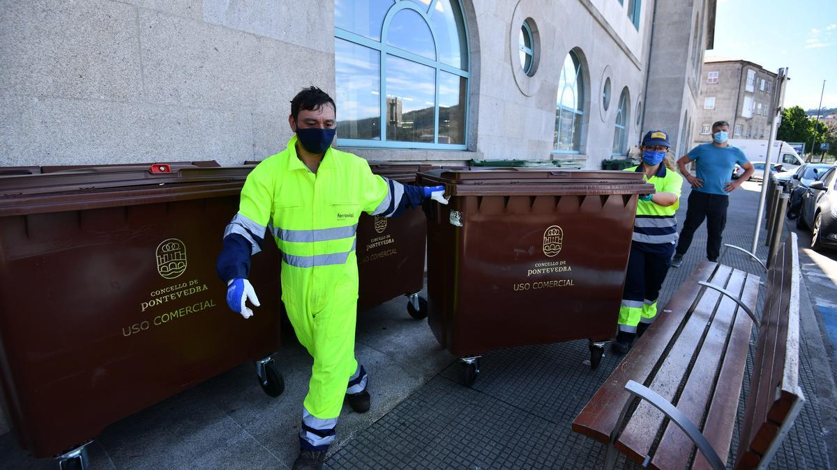Dos operarios recogen el contenedor marrón destinado a los biorresiduos.