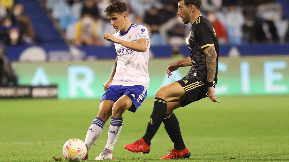 Francés golpea el balón ante la presencia del delantero de la Ponferradina Sergi Enrich.