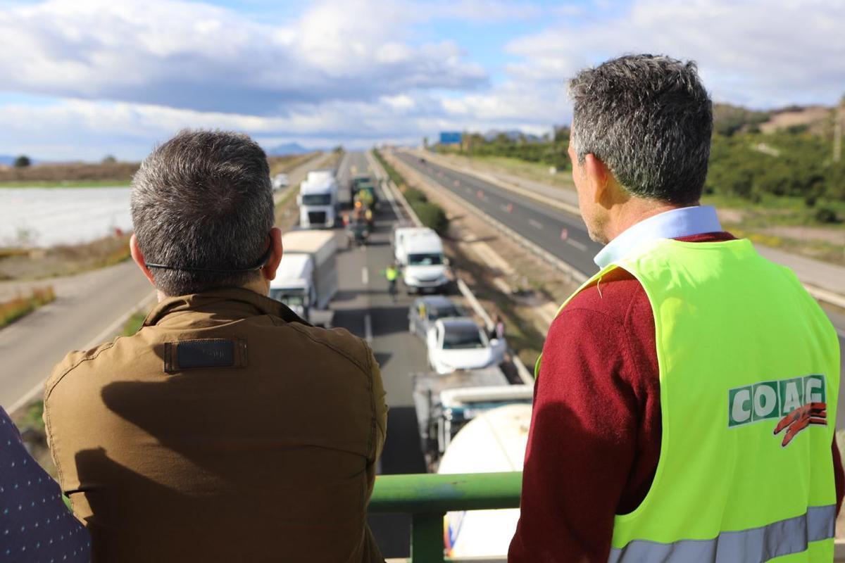 Los líderes agrarios observan la columna  de vehículos que colapsa la autovía en Lorca.