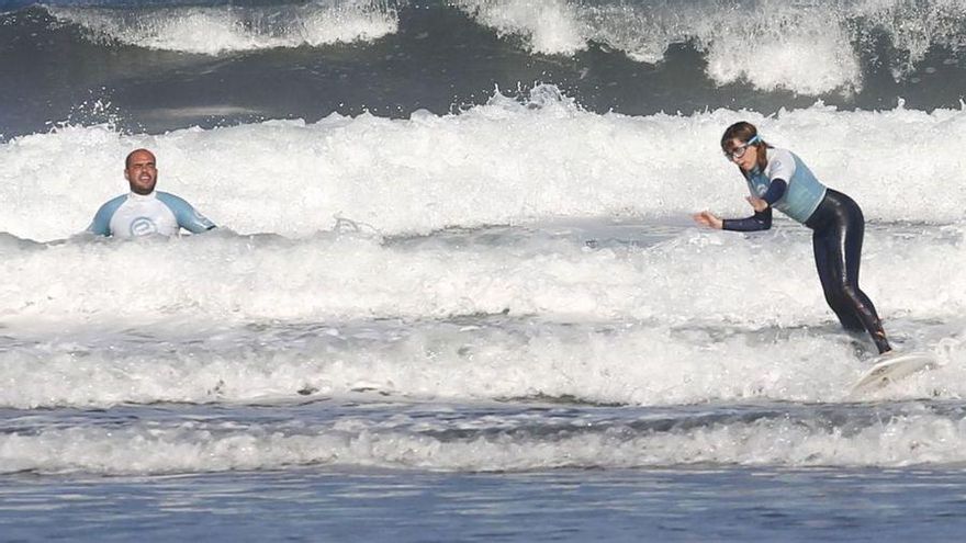 La joven, haciendo surf en Salinas, junto a Lucas García, en una fotografía de 2018. / Mara Villamuza