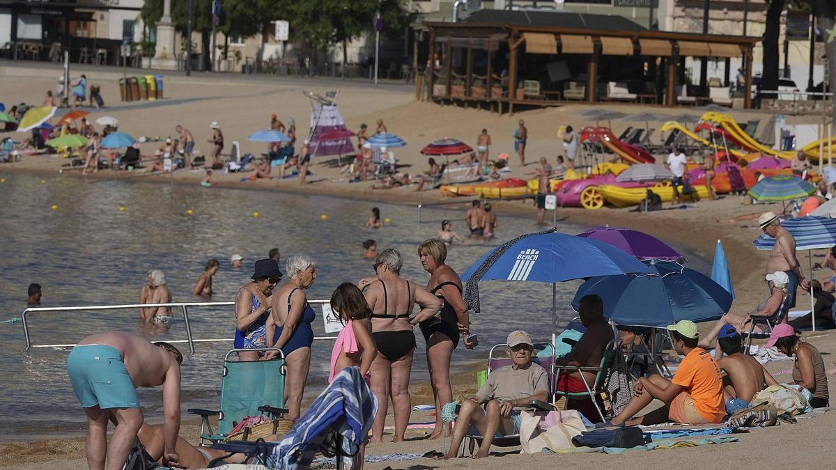 Diverses persones a la platja de Sant Feliu de Guíxols