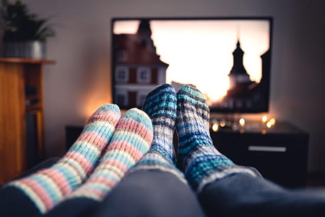 Una pareja mira la pantalla de la televisión en invierno