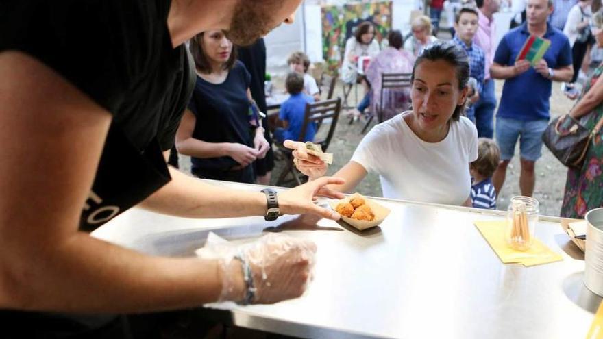 Uno de los puestos de comida instalados en Las Mestas; a la derecha, Jonás Gallego conduce el carrito de los zumos por el recinto.