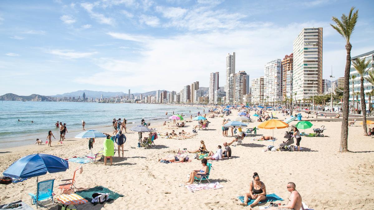 Numerosas personas se bañan y toman el sol en la playa de Poniente, a 11 de marzo de 2023, en Benidorm, Alicante, Comunidad Valenciana (España).