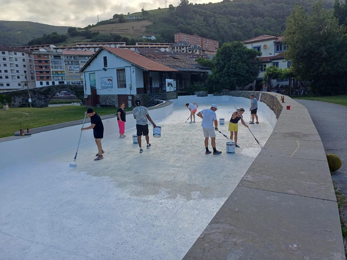 Miembros de la asociación pintando la presa la tarde de este miércoles.