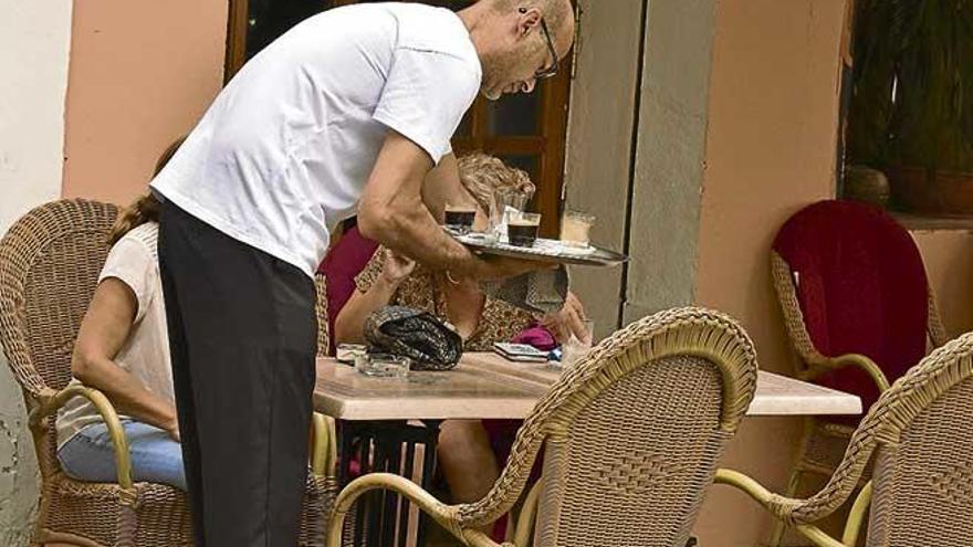 Un camarero atiende a unos clientes en un bar de Palma.
