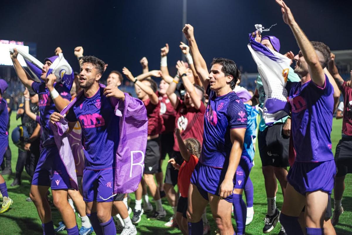 El tinerfeño, en el centro, celebra el ascenso sobre el césped.