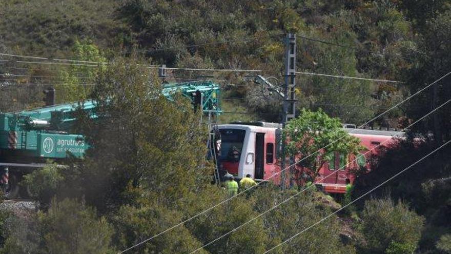 Operaris de Ferrocarrils de la Generalitat amb una grua de gran tonatge intentaven adreçar el comboi