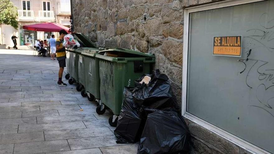 Contenedores de basura con bolsas en el exterior en las inmediaciones de Curros Enríquez. // G. Santos