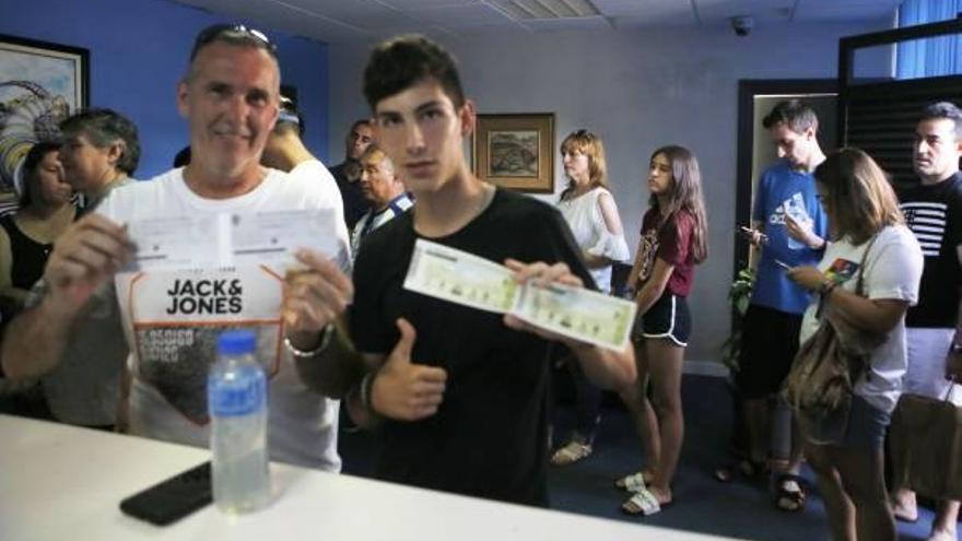 Dos aficionados posan con sus entradas para El Toralín, ayer, en las oficinas del Rico Pérez.