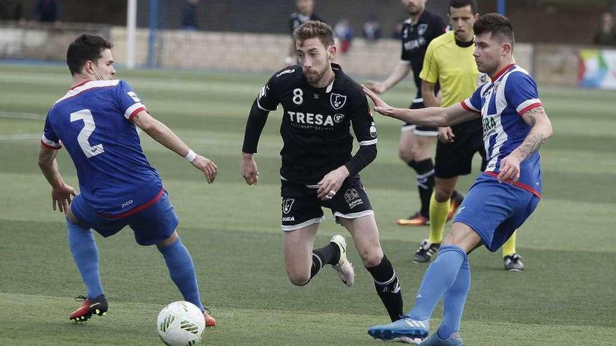 Robert trata de zafarse del marcaje de dos jugadores del Izarra, en el partido disputado ayer en Estella.