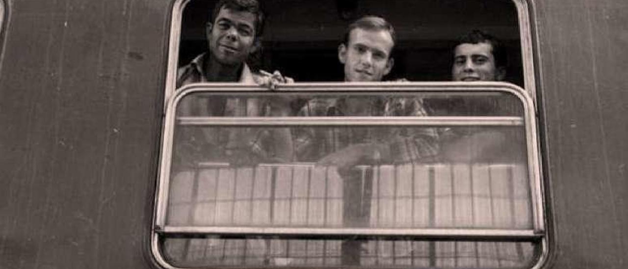 Emigrantes asomados a la ventanilla de un tren