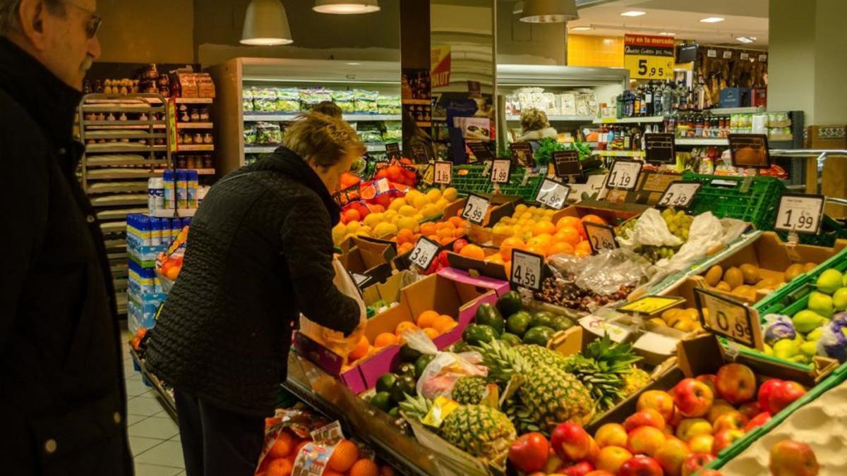 Una mujer compra fruta en un supermercado.