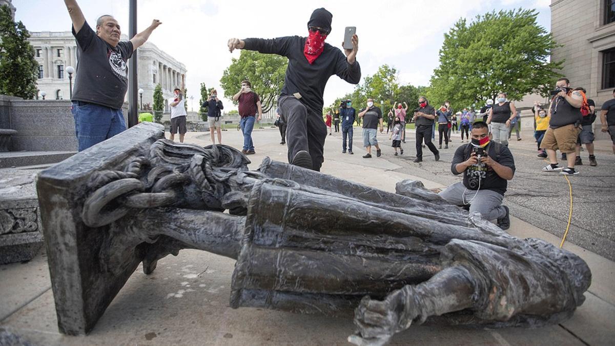 Varios hombres celebran el derribo de una estatua de Cristóbal Colón en Saint Paul (Minnesota), el 19 de junio