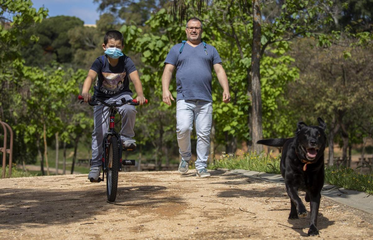 Archivo - Un niño protegido con mascarilla monta en bici junto su padre y su perro, el primer día en el que los menores de 14 años pueden salir a la calle, en Huelva (Andalucía ,España) a 26 de abril de 2020.