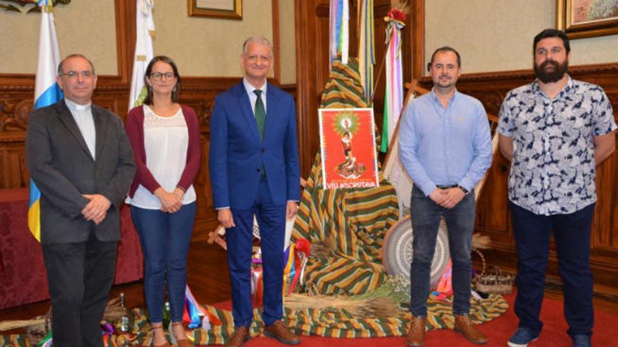 Autoridades locales, el autor del cartel y el párroco de La Concepción posan junto a la obra.