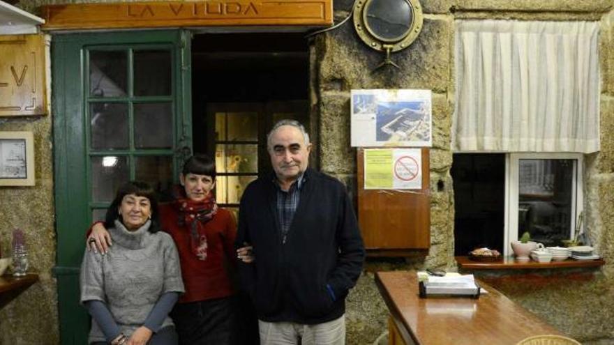 Paco Barreiro y Puri Graña, con su hija en el centro, son la tercera generación familiar que regenta la taberna La Viuda, en Bueu.  // G.Núñez