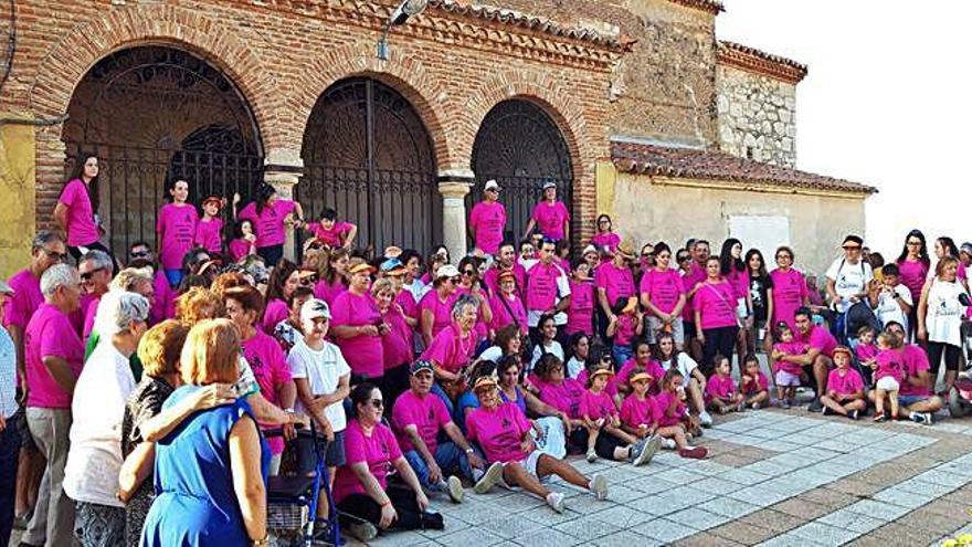 Participantes en la marcha solidaria con las camisetas rosas preparadas por la organización.