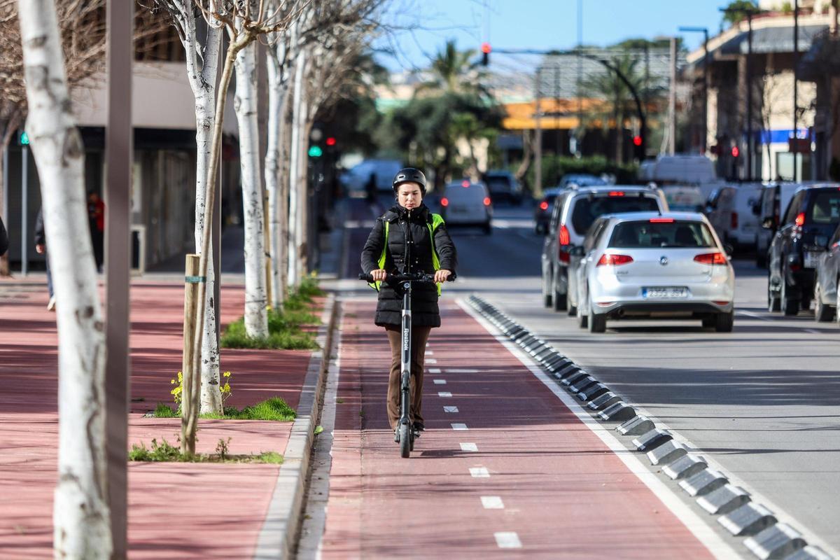 Una mujer circula por el carril bici en su patinete