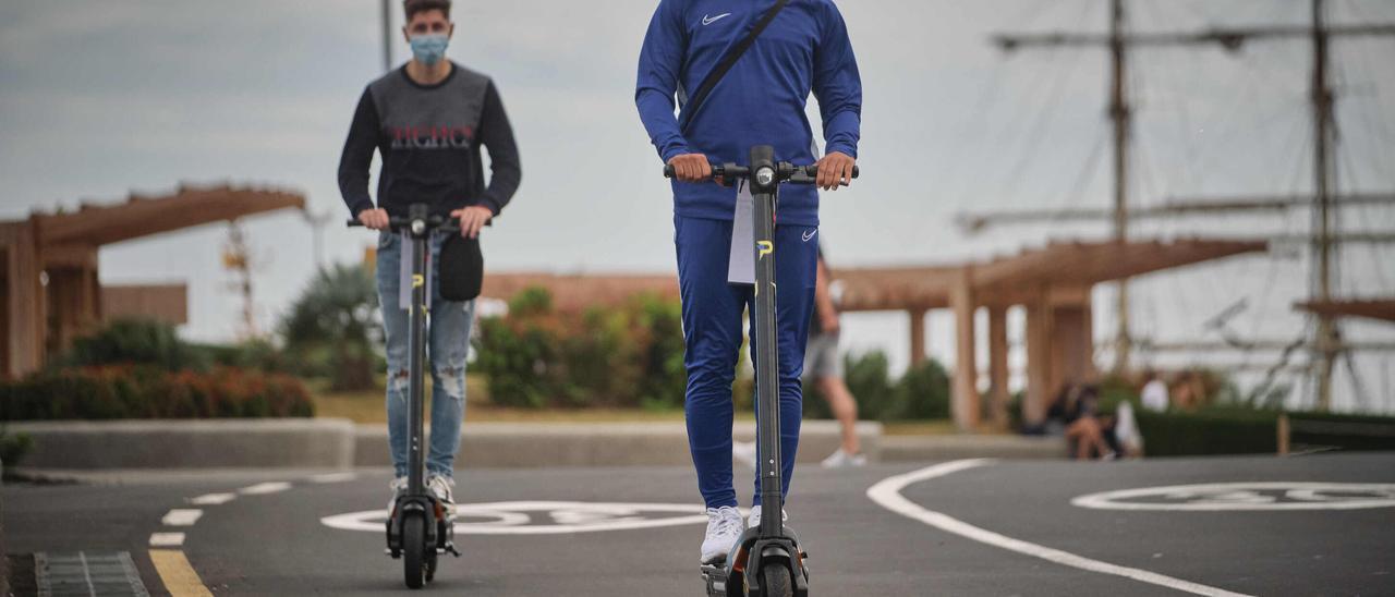 Dos ciudadanos circulan por la ciudad en patinete eléctrico