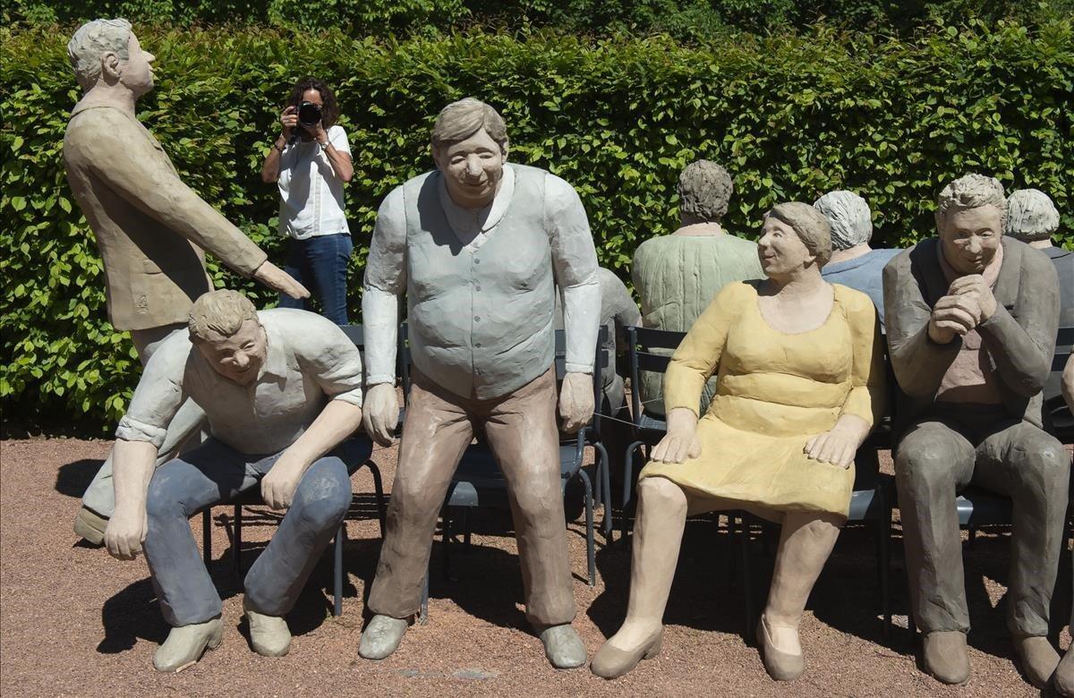 Una mujer fotografía a un grupo de esculturas durante la exposición ’Ordinary People’ de Christel Lechner en el jardín barroco del castillo de Lichtenwalde cerca de Chemnitz, Alemania. La idea artística de Lechner es crear una idea simple. Figuras que pueden aparecer donde quiera que vayas en tu vida cotidiana. Las estatuas se han instalado como arte público en entornos del mundo real. La exposición comenzó hoy y durará hasta el 3 de noviembre de 2019.