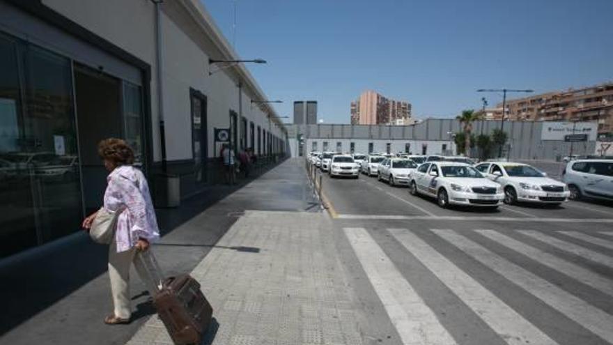 Una mujer entra en la estación del AVE de Alicante junto a la parada de taxis.
