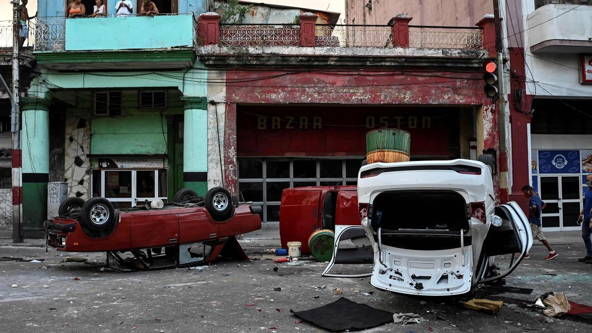 Vehículos de policía vandalizados en una calle de La Habana durante el estallido de julio de 2021.