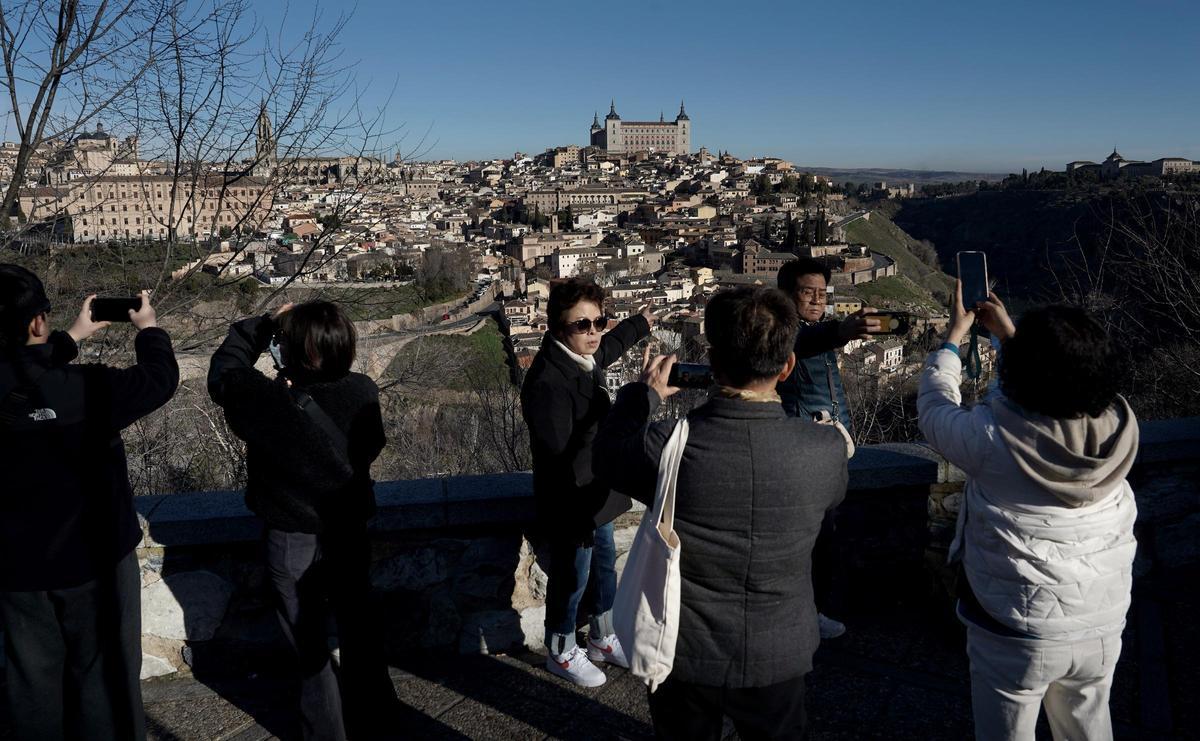 Varios turistas orientales hacen fotografías en uno de los miradores panorámicos de la ciudad de Toledo
