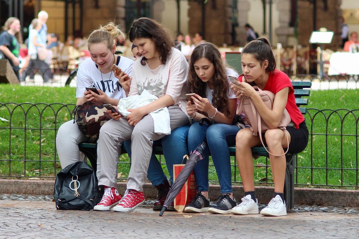 Adolescentes con sus móviles.