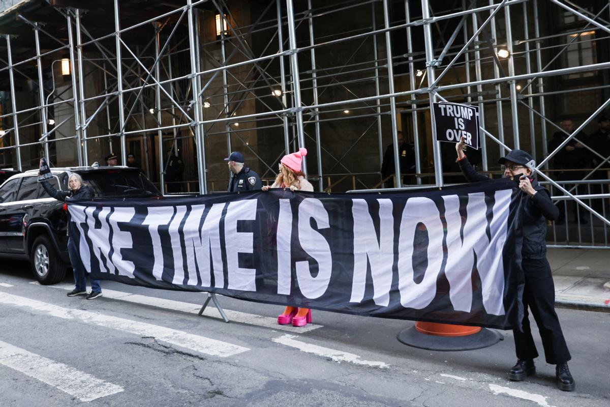 Manifestantes sostienen una pancarta después de la acusación del expresidente estadounidense Donald Trump por parte de un gran jurado de Manhattan.