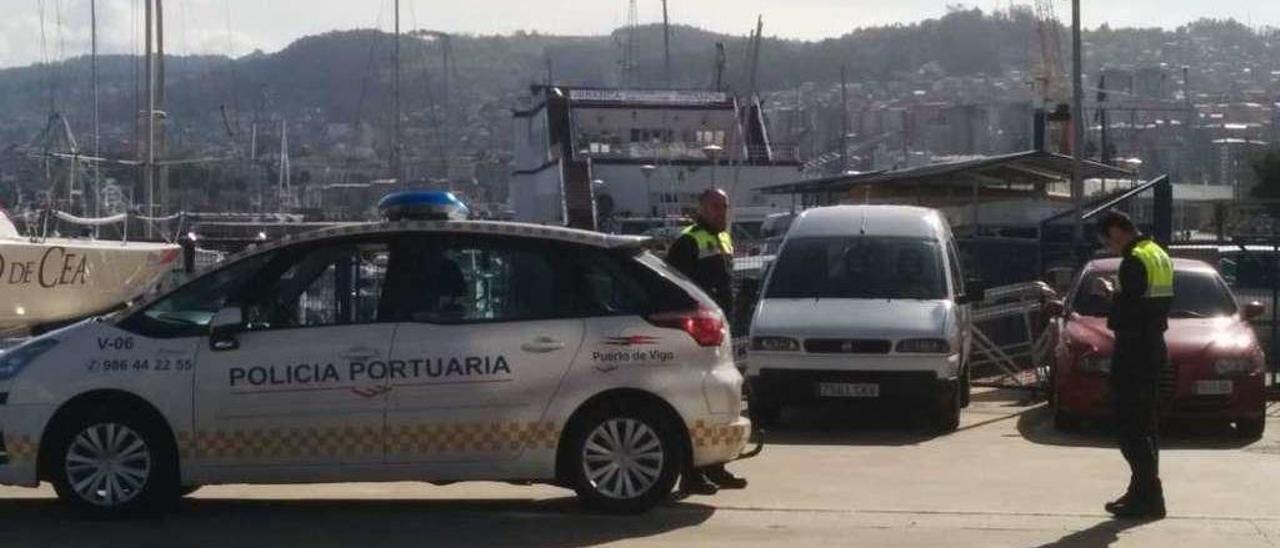 Agentes de la Autoridad Portuaria multando a vehículos aparcados en la zona del Náutico. // A.B.