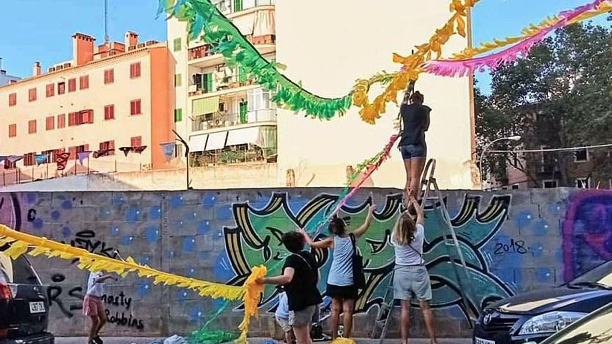 Vecinos de la barriada decoran las inmediaciones del solar de la Casa del Pueblo.