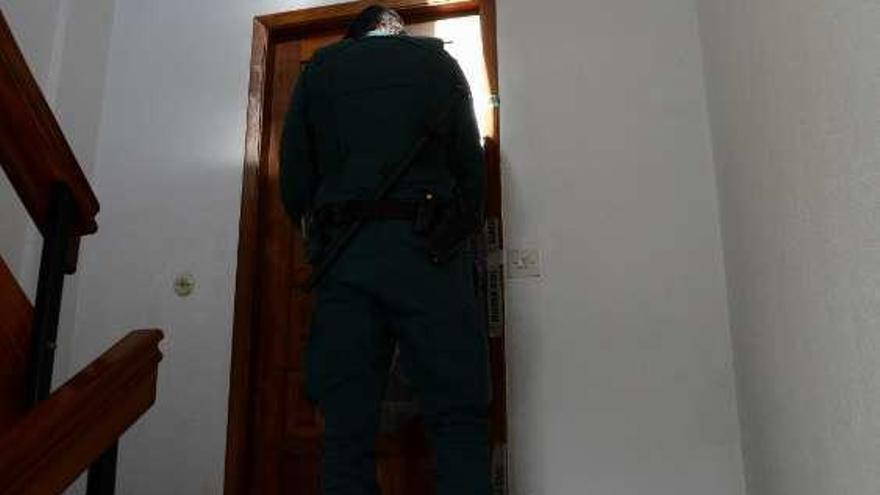 Un Guardia Civil custodia el acceso a la vivienda. // G.N.