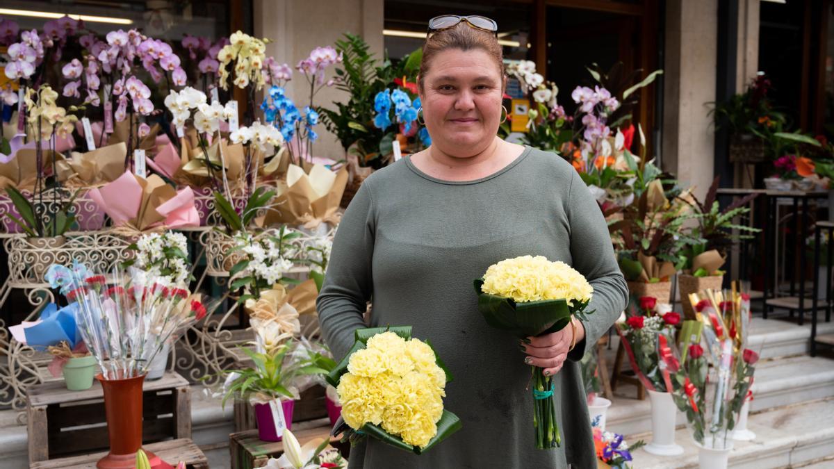 Clara sostiene dos de los ramos de claveles, muy tupido y repleto de flor, que ha preparado para la ofrenda a la Mare de Déu del Lledó.