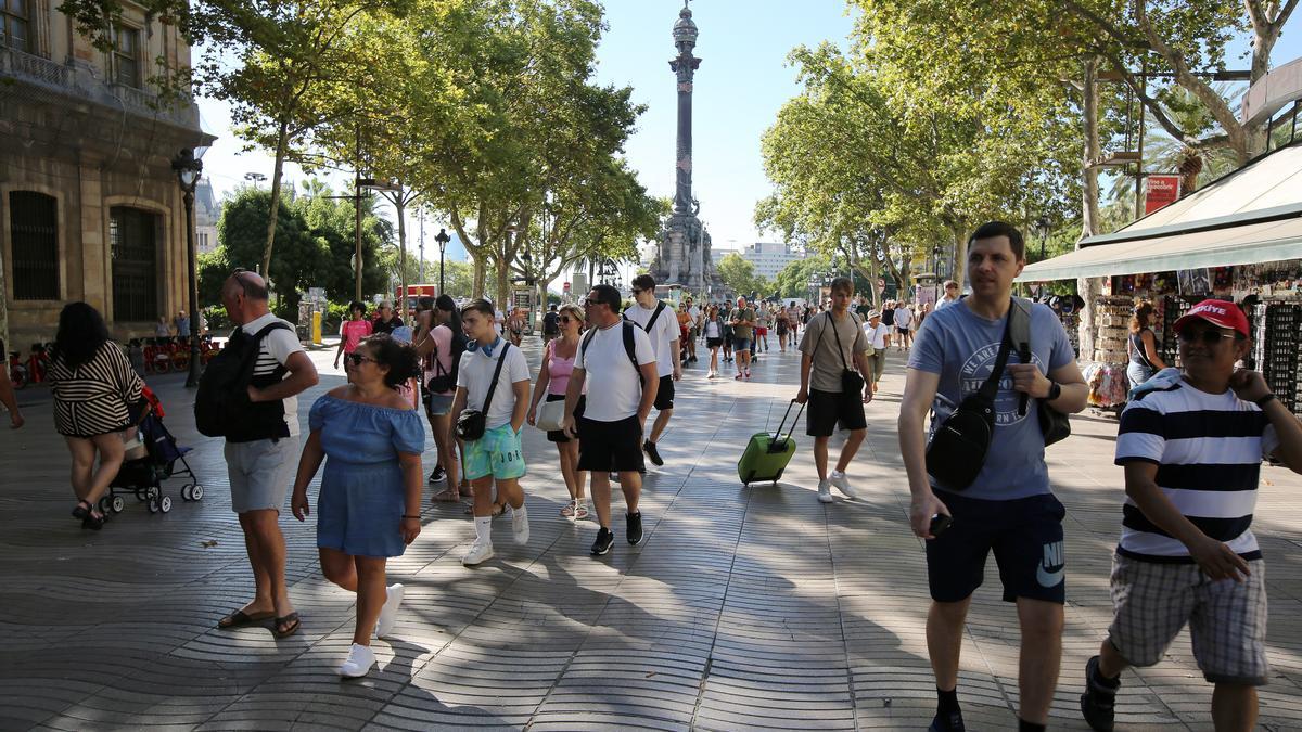 Cruceristas del mayor barco que atracó este viernes en Barcelona, salen a pasear por la Rambla, donde les dejan los buses.