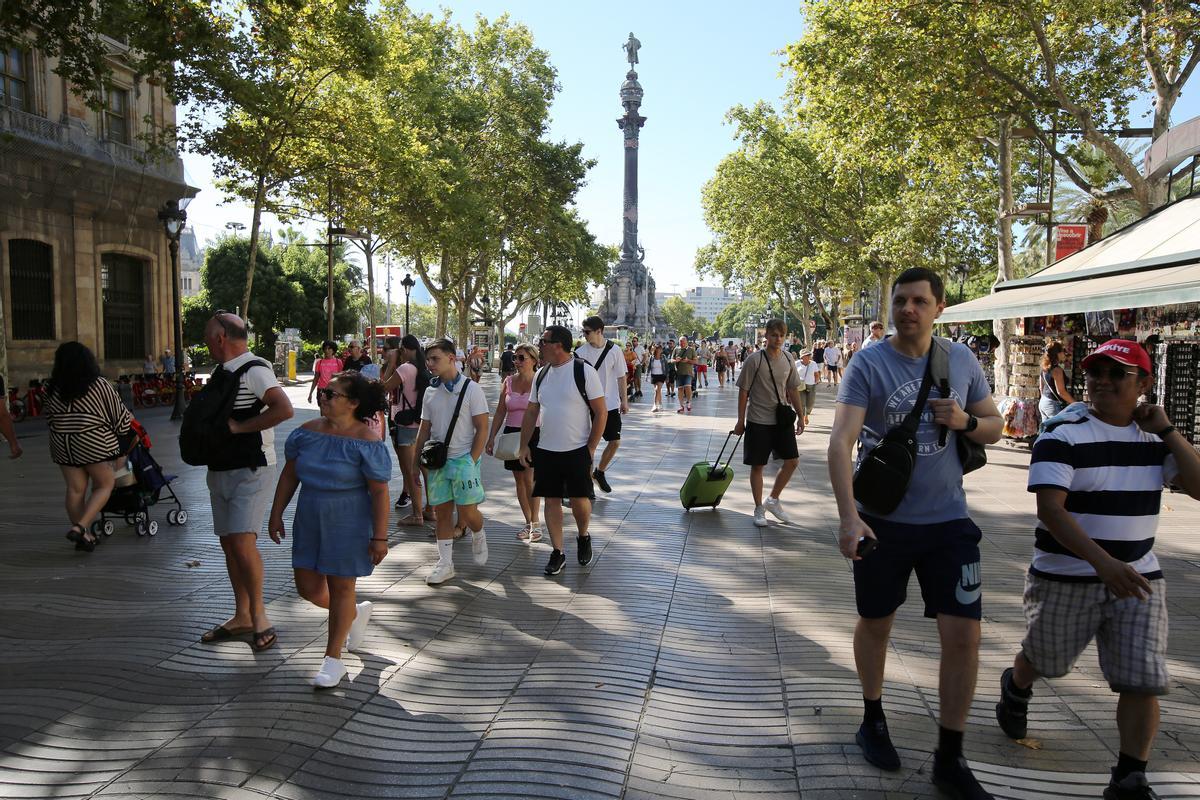 Cruceristas del mayor barco que atracó este viernes en Barcelona, salen a pasear por la Rambla, donde les dejan los buses.