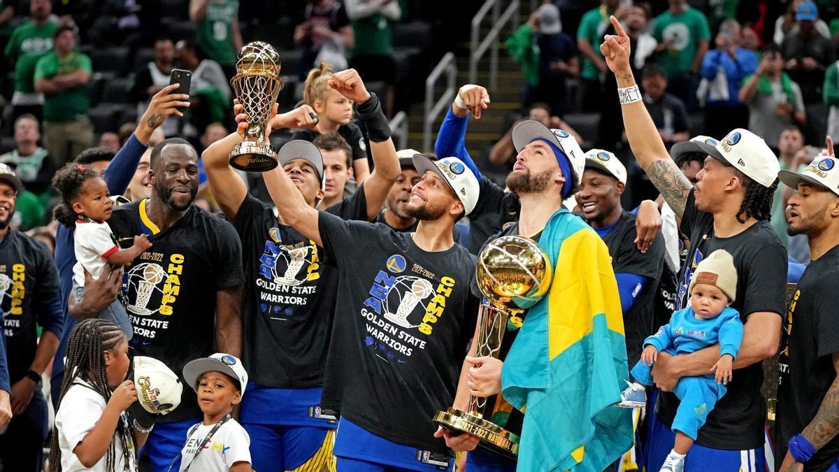 Stephen Curry contempla el trofeu de MVP de les finals flanquejat per Green, Poole i Thompson, entre altres companys dels Golden State Warriors