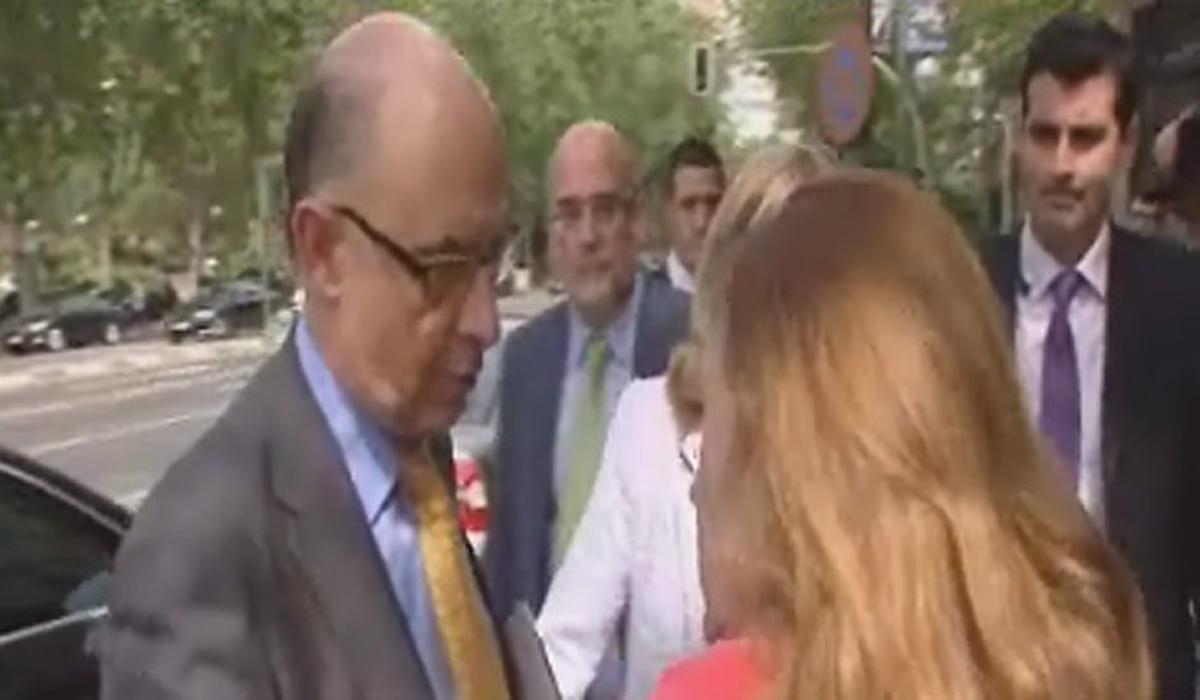 Una dona interpel·la a Montoro sobre el futur de Bankia al mig del carrer.