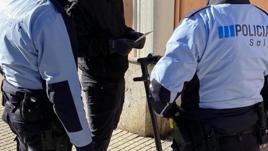 Dos agents de la Policia Local de Salt controlant que un usuari de patinet elèctric compleixi amb la normativa de circulació