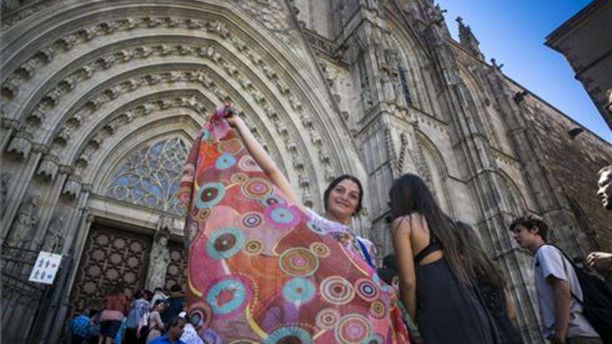 Una mujer vende pareos ante la catedral de Barcelona