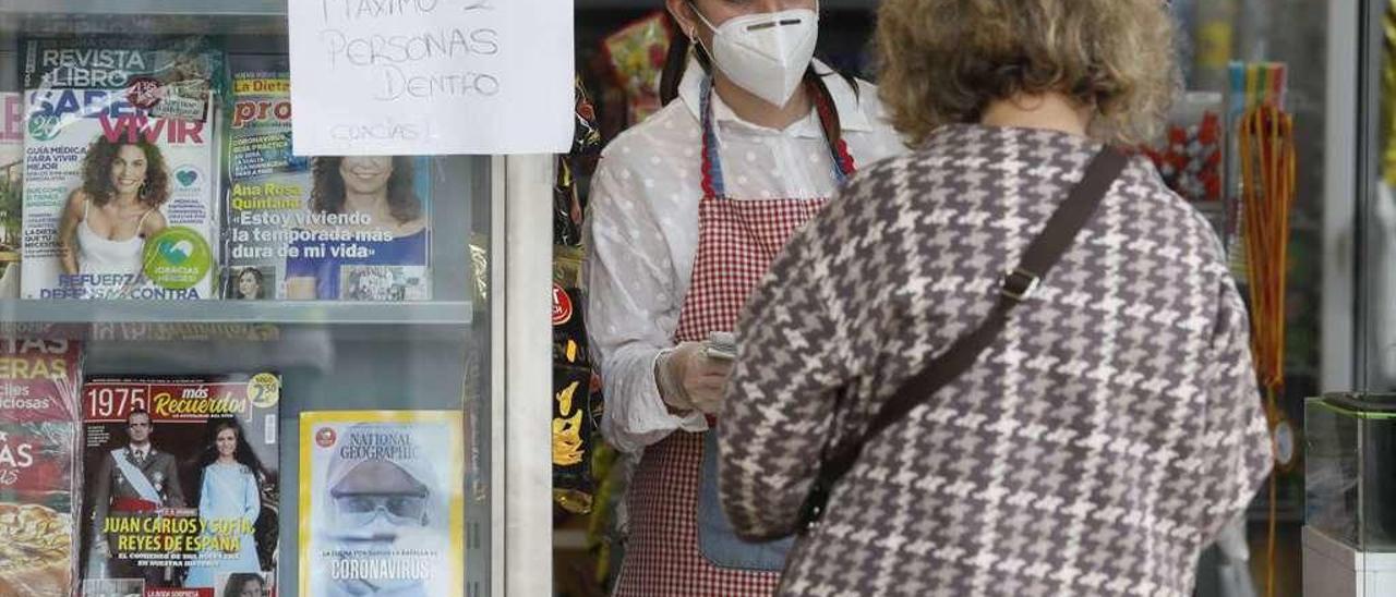 Una comerciante avilesina atiende a una clienta.