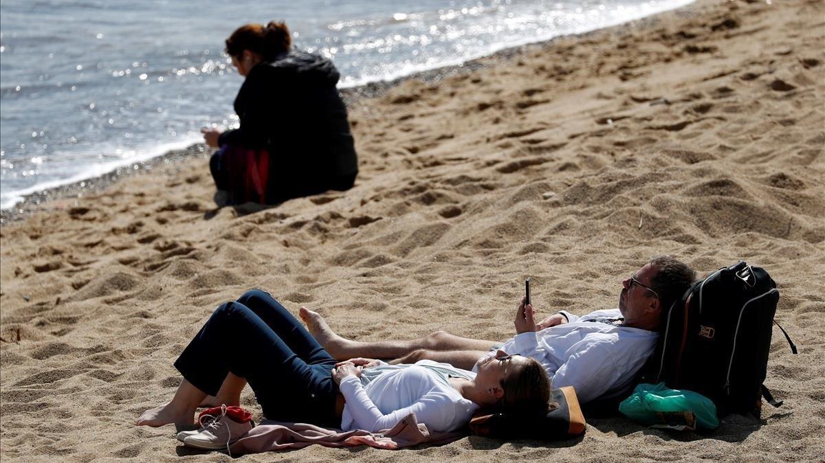 Varias personas toman en sol en la playa en Barcelona el pasado fin de semana.
