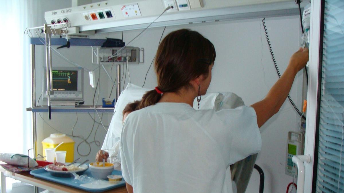 Foto de archivo de una enfermera atendiendo a un paciente hospitalizado.