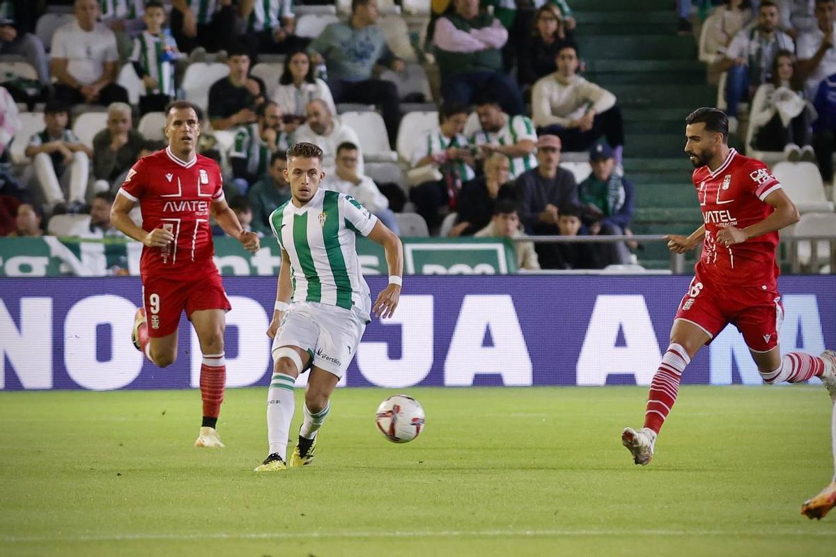 Isma Ruiz pasa el balón entre Luis Muñoz y Ortuño.