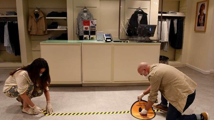 Un trabajador de El Corte Inglés, ayer, coloca medidas de seguridad para su reapertura.