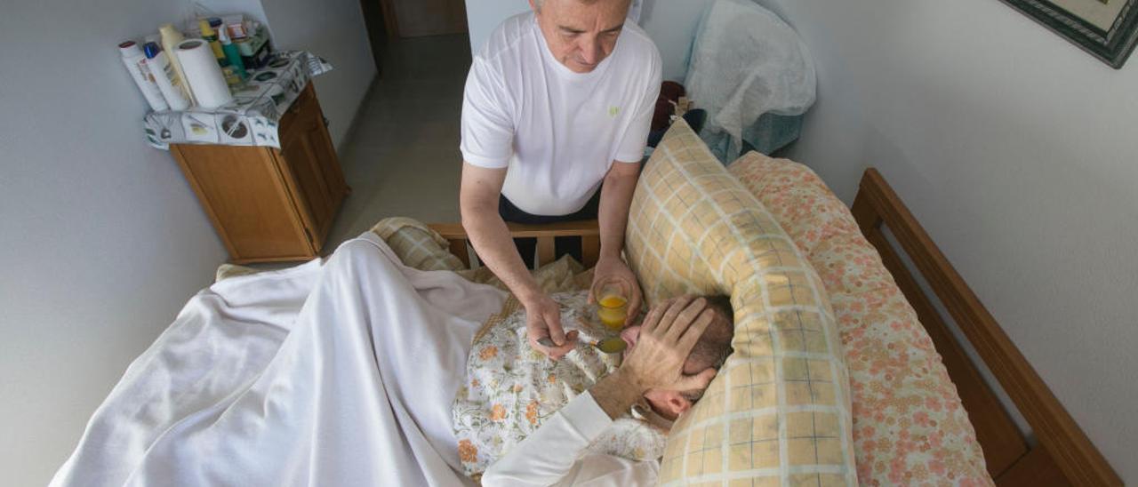 Una persona dependiente asistida en su domicilio por un cuidador.