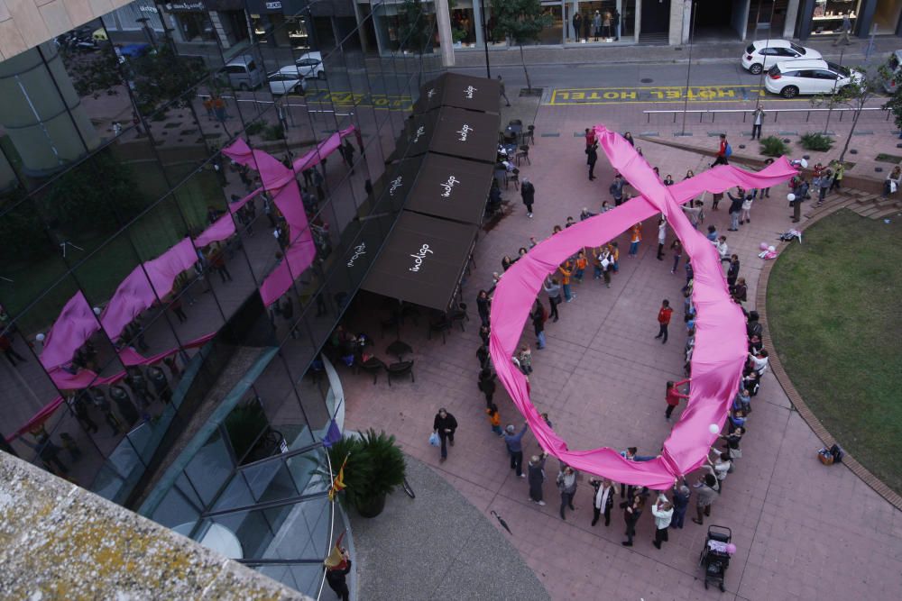 Un centenar de persones van crear el llaç rosa gegant de l''Oncolliga a la ciutat de Girona