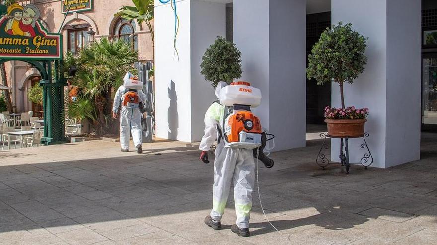 Dos operarios desinfectan los alrededores del Palacio de Ferias.