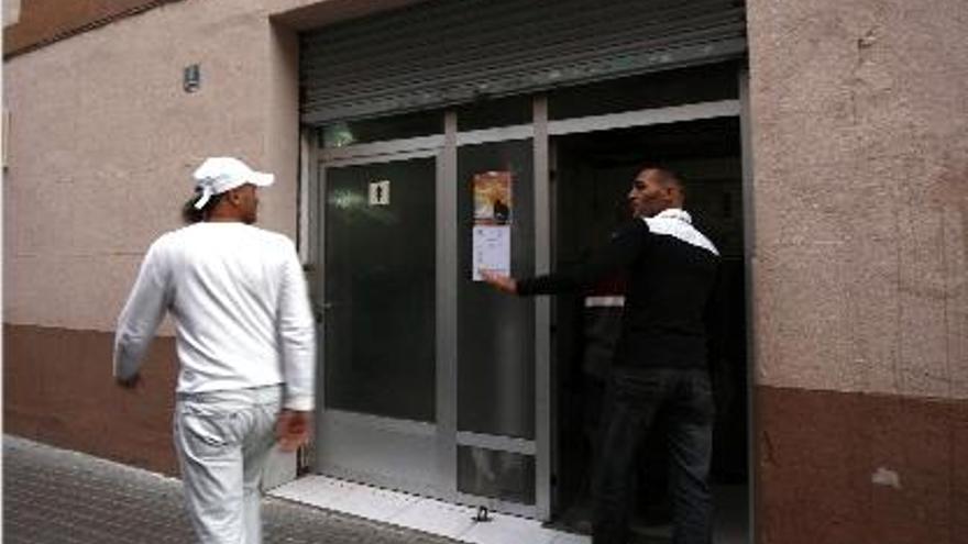 Dos miembros de la comunidad musulmana se saludan, ayer, a la puerta de la mezquita.