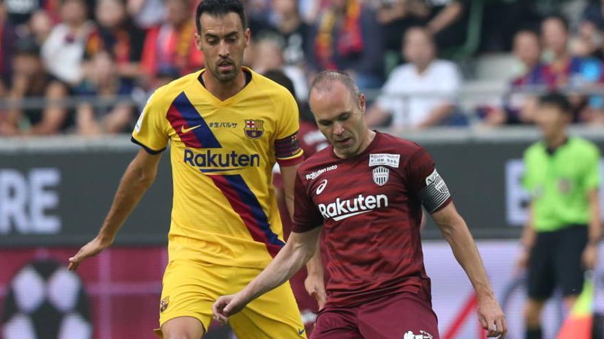 Iniesta disputa un balón con Sergio Busquets.